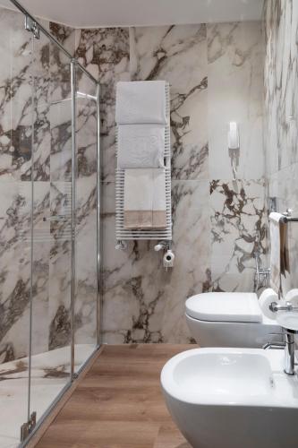 a bathroom with a toilet and a sink and a shower at Residence Carl&Do in Baveno