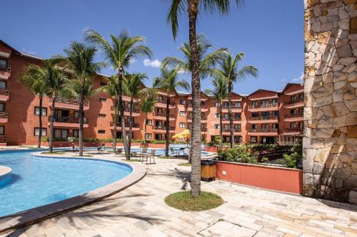 un complexe avec une piscine et des palmiers dans l'établissement Linda Suíte em Apart-hotel com vista incrível!!!, à Cumbuco