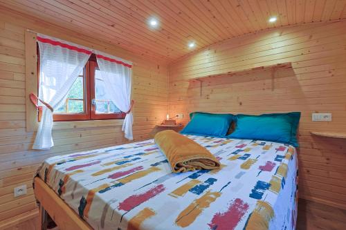 a bedroom with a bed in a wooden cabin at Roulotte au cœur des vignes, Hyères in Hyères