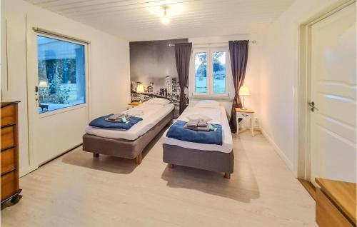 a bedroom with two beds and a window at Lovely Home In Lvestad With House A Panoramic View in Lövestad