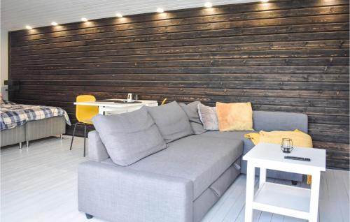 a living room with a couch and a wooden wall at Lovely Home In Tomelilla With Kitchen in Tomelilla