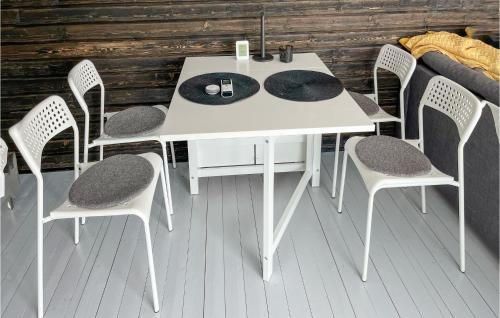 - une table et des chaises blanches sur une terrasse couverte dans l'établissement Lovely Home In Tomelilla With Kitchen, à Tomelilla