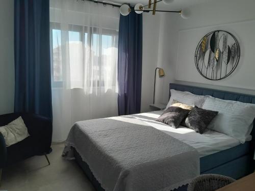 1 dormitorio con 1 cama y una ventana con cortinas azules en Penthouse Aurelia, rooftop terrace & jacuzzi, en Turanj