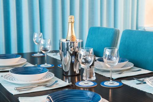 a table with a bottle of champagne and glasses on it at Billy's Place Protaras Luxury Villa with private pool with heated pool option for autumn and winter months in Paralimni