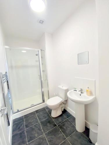a bathroom with a toilet and a shower and a sink at Friars House, Stafford by BELL Apartments in Stafford