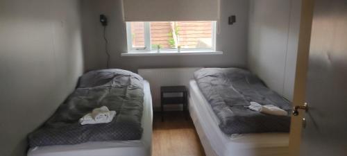 2 łóżka w małym pokoju z oknem w obiekcie Budanes 1 w mieście Stykkishólmur