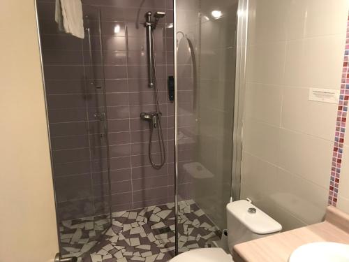 a bathroom with a glass shower with a toilet at Hostel Ramuntcho in Saint-Jean-Pied-de-Port