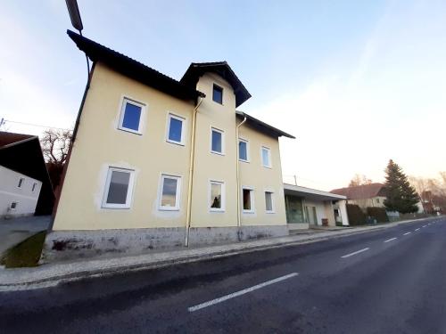 a yellow house on the side of a street at Große Altbauwohnung auf dem Land in Kallham