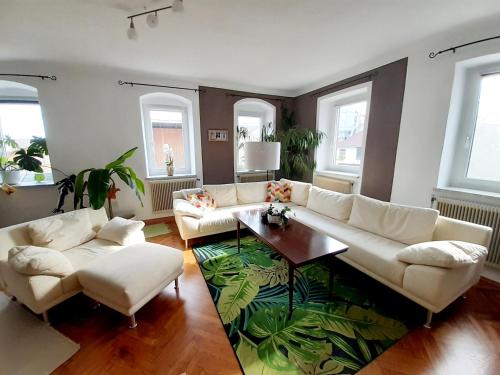 a living room with a white couch and a table at Große Altbauwohnung auf dem Land in Kallham