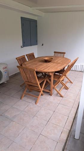 a wooden table and chairs in a room at Villa tempÔ in Sainte-Rose