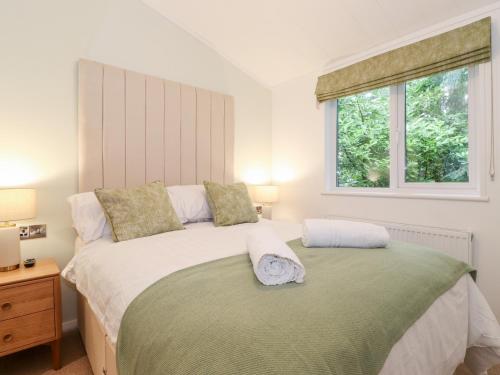 a bedroom with a large bed and a window at Unique Luxury Lodge in Windermere