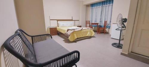a bedroom with a bed and a chair in it at Hotel La Suite de Angelique Huacho in Huacho
