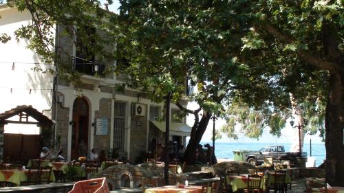 a restaurant with tables and chairs in front of a building at Guesthouse Aktaion in Afissos