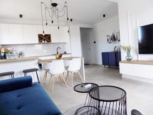 sala de estar y cocina con sofá azul y sillas en Penthouse Aurelia, rooftop terrace & jacuzzi, en Turanj