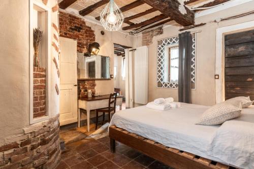 a bedroom with a bed and a desk in a room at Casa Scaparone in Alba