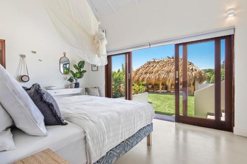 um quarto branco com uma cama e uma grande janela em Villa Blou, steps from the Jan Thiel Beach em Jan Thiel