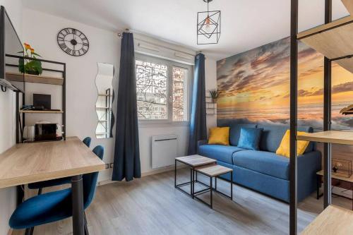 un salon avec un canapé bleu et une table dans l'établissement bnbgônes - LE LOMBARDI - METRO GARIBALDI - WIFI, à Lyon