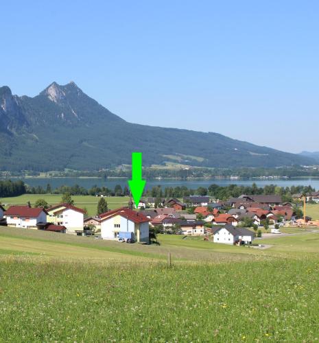 a green arrow pointing to a town with houses at Ferienwohnung Lindpointner in Innerschwand am Mondsee