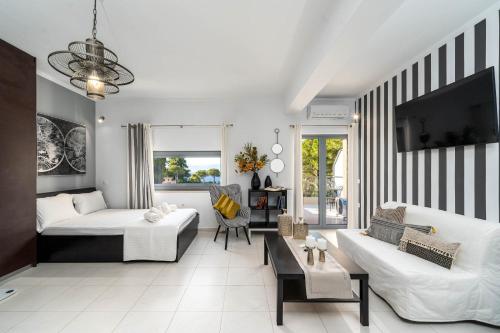 een woonkamer met een bed en een bank bij Byron Luxury Apartments in Aigio