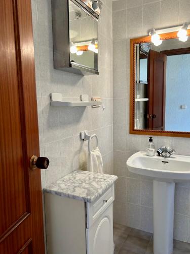 a bathroom with a sink and a toilet and a mirror at Casa CaboMar in Torrevieja