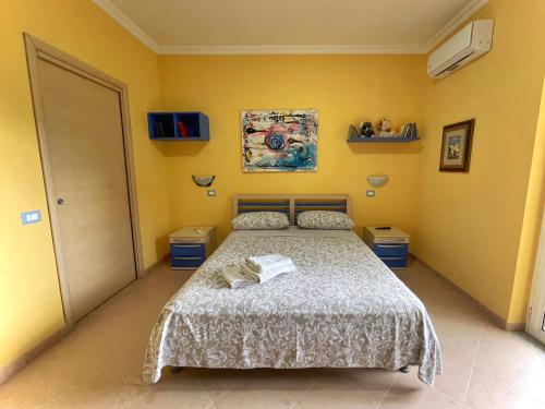 ein Schlafzimmer mit einem Bett und gelben Wänden in der Unterkunft Camera con ingresso indipendente in Ogliastro Cilento
