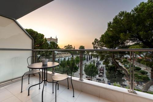 balcone con tavolo, sedie e vista sulla città di Byron Luxury Apartments a Aigio