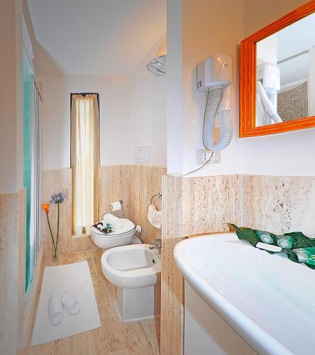 ein Badezimmer mit Toilette, Waschbecken und Badewanne in der Unterkunft Hotel Scott House in Rom