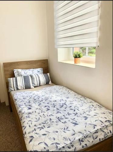 a bed in a bedroom with a window and a bedspread at Útulný byt v Jizerských horách -Apartmán Mili in Kořenov