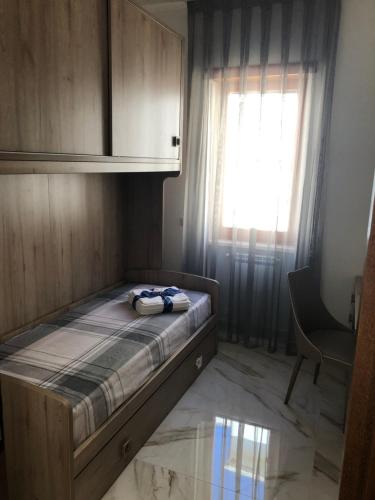 um pequeno quarto com uma cama e uma janela em B&B Dipace Apartment em Lecce