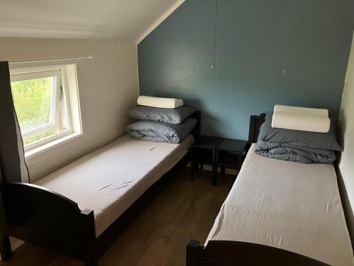 2 Betten in einem kleinen Zimmer mit Fenster in der Unterkunft 极光民宿Northern Lights in Laksvatn