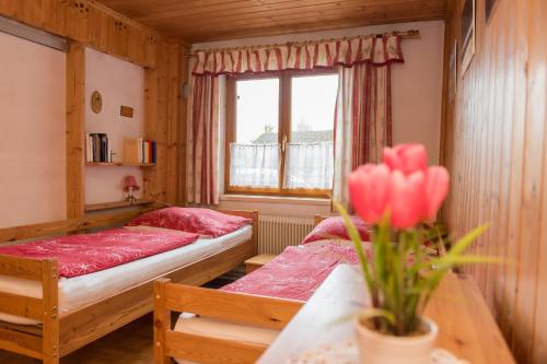 a bedroom with two beds and a table with a vase of flowers at Katschwaldhütte in Sankt Wolfgang