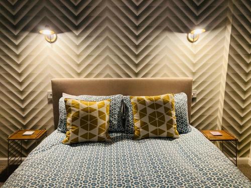 um quarto com uma cama com almofadas e uma parede em Glenarch House em Dalkeith