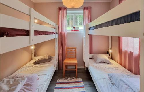 2 Etagenbetten in einem Zimmer mit einem Stuhl und einem Fenster in der Unterkunft Awesome Home In Alingss With Wifi And 2 Bedrooms in Alingsås