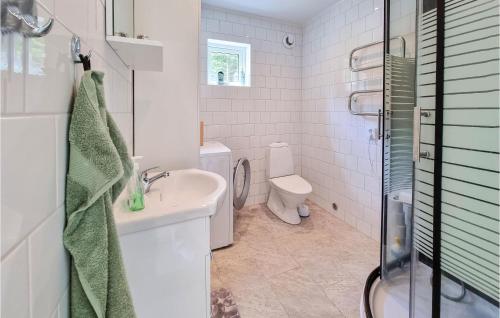 La salle de bains blanche est pourvue d'un lavabo et de toilettes. dans l'établissement Lovely Home In Alingss With Wifi, à Alingsås