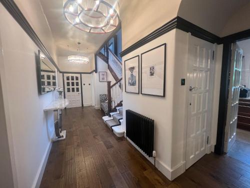 a hallway with a staircase and a hallway with a hallway at Edwardian Manor near Glasgow City with HEATED POOL & HOT TUB in Giffnock