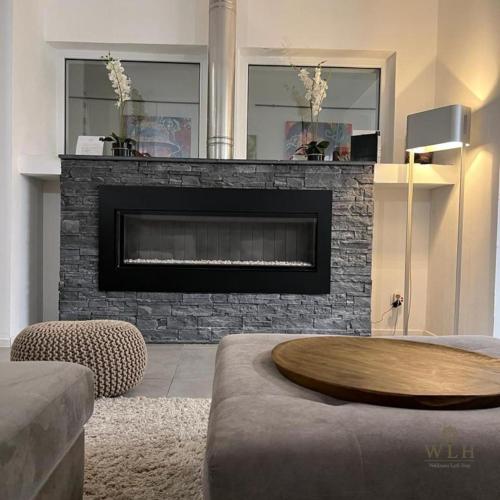 a living room with a fireplace with a wooden table at Wellness Loft Huy in Huy