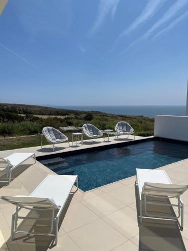 a swimming pool with chaise lounge chairs and a swimming pool at Amazing Sea View Beach House in Lourinhã