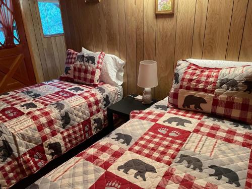 a bedroom with two beds and a table with a lamp at White Owl Retreat Yellowstone Grand Teton in Island Park
