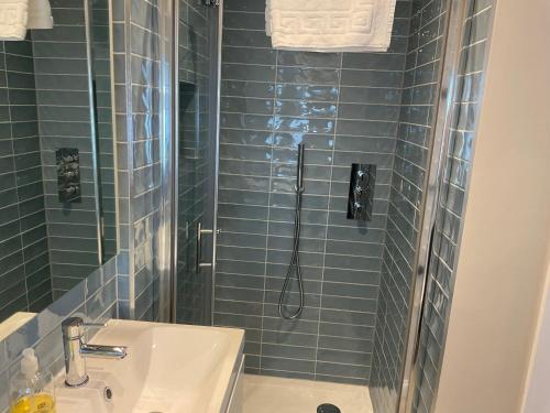 a bathroom with a shower and a sink at Sunnyside Cottage in Crantock