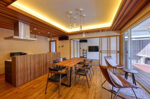 a dining room with a wooden table and chairs at グランド―ム　富士忍野 in Minamitsuru
