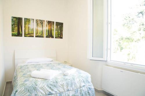 una camera bianca con un letto e una finestra di Guest House Garden dei Mille a Reggio Emilia