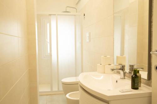 bagno bianco con lavandino e servizi igienici di Guest House Garden dei Mille a Reggio Emilia
