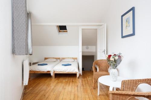 een slaapkamer met een bed en een tafel en stoelen bij LE BLANC CENTRE F2 in Le Blanc-Mesnil