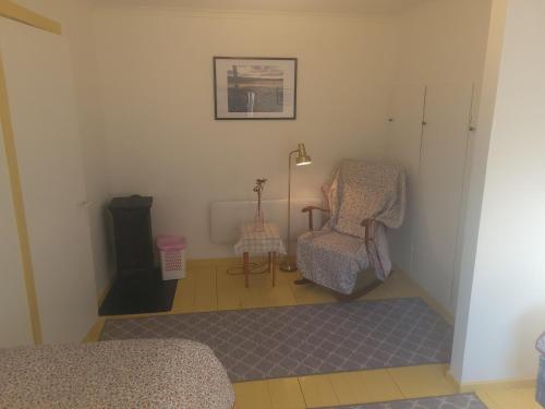 a living room with a chair and a lamp at Paul's House in Saltstraumen