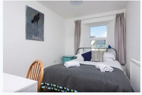 um quarto com uma cama com uma janela e uma cama sidx sidx em bEaUtiFUL and Bright !! Town/Harbour apartment #2 em Penzance