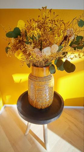 a vase filled with flowers sitting on a table at Luxe Natuurhuis Veluwe Home 'De Bosvogel' in Ermelo