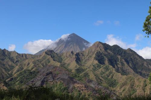 a mountain covered in green and brown mountains at Home stay wolokoro ecotourism in Bajawa