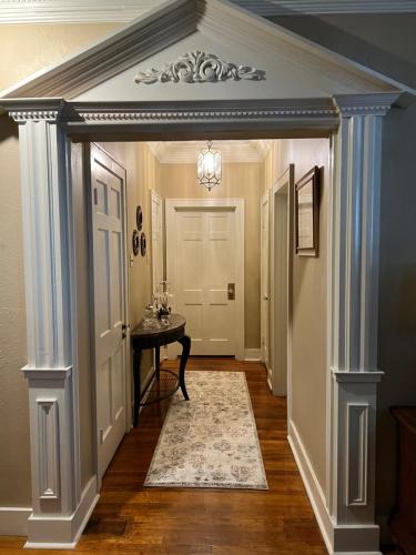a hallway with white columns and a table in a house at Opus House Historic Natchitoches in Natchitoches