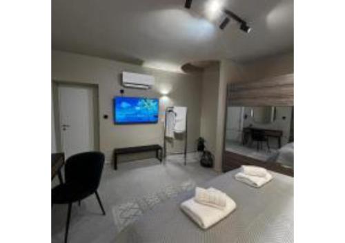 - une chambre avec un lit et une télévision murale dans l'établissement On The Sea Suite&Spa, à Methana