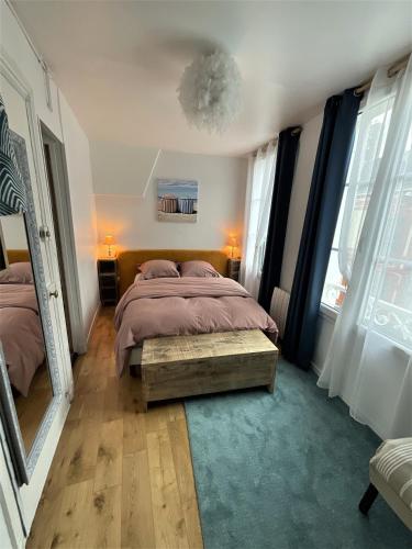 une chambre avec un lit et une grande fenêtre dans l'établissement Petite Bulle, à Trouville-sur-Mer